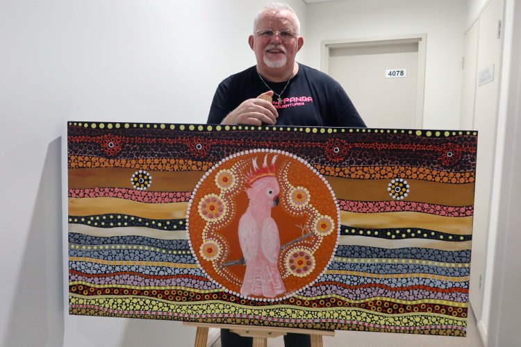 Robb Wang with a cockatoo painting